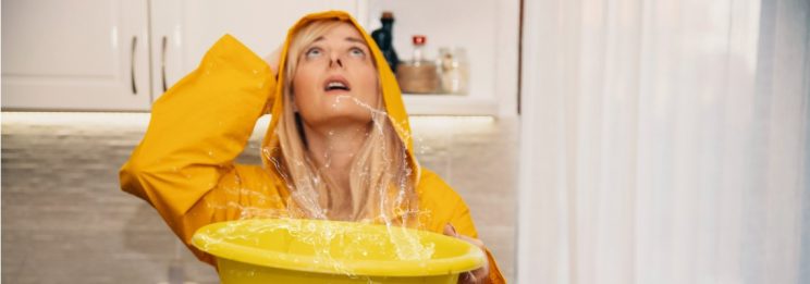 woman collecting water leaking from ceiling