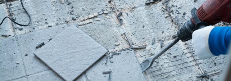 old tiles being removed using a hammer and wall breaker.