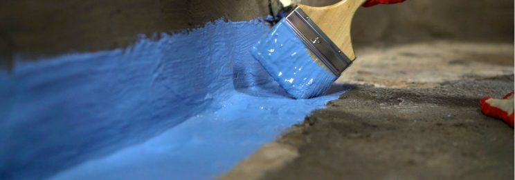 waterproofing the bathroom floor with a brush