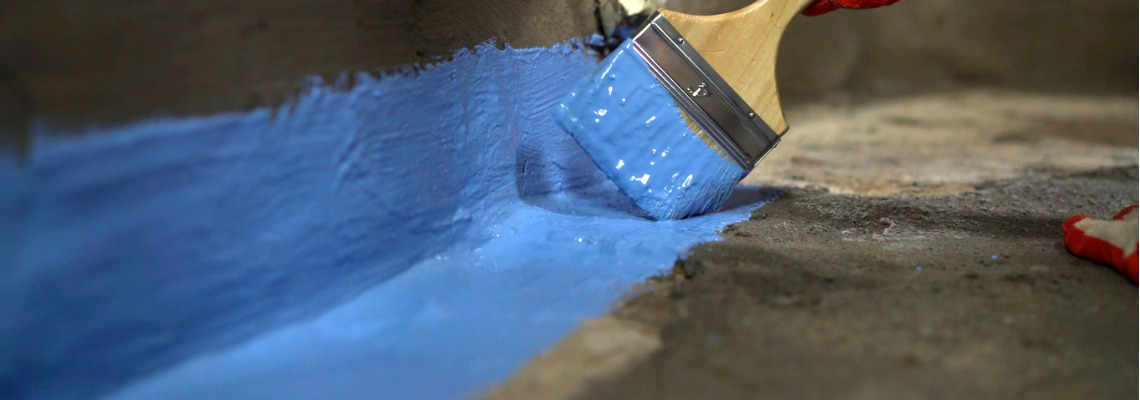 waterproofing the bathroom floor with a brush